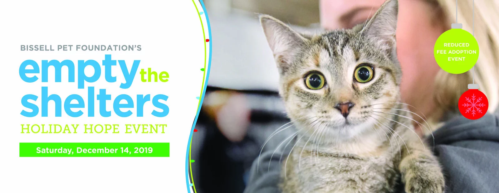 A woman holds a tabby cat with green eyes in front of a holiday-themed banner for Bissell Pet Foundation’s “Empty the Shelters Holiday Hope Event,” featuring reduced-fee pet adoptions on December 14, 2019.